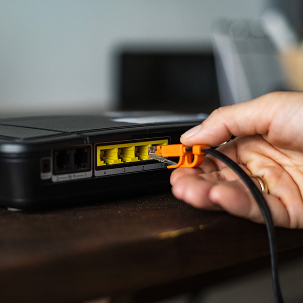 carre-man-plugging-ethernet-cable-wireless-router